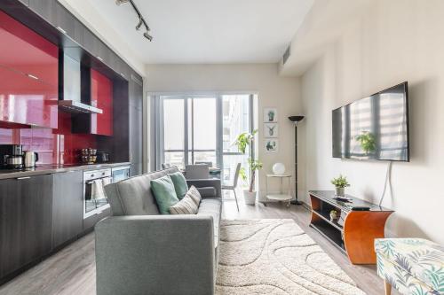 a living room with a couch and a kitchen at Modern Suite w City Views - Downtown in Toronto