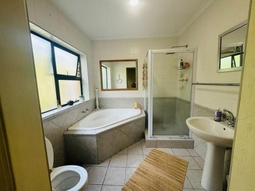 a bathroom with a tub and a toilet and a sink at Clearwater view in Cape Town
