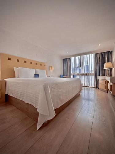 a large bedroom with a large bed and a large window at Hotel Stella Maris in Mexico City