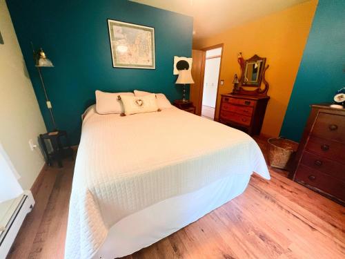 a bedroom with a bed and a dresser and a mirror at Peek of the Bay in Suttons Bay
