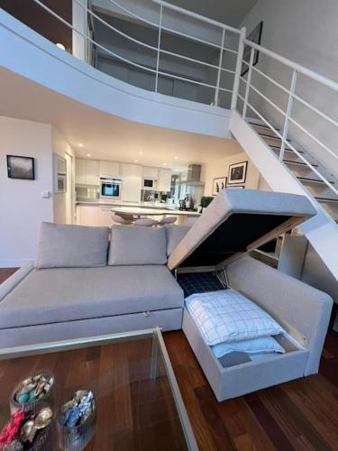 un salon avec un canapé et un escalier dans l'établissement Loft Paris Secret Tour Eiffel, à Paris