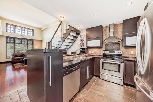 a kitchen with stainless steel appliances and a staircase at Copper Point Resort in Invermere