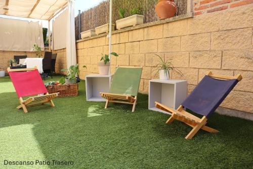 three lawn chairs sitting on the grass in a yard at Residencial Entreaguas in Palazuelos de Eresma