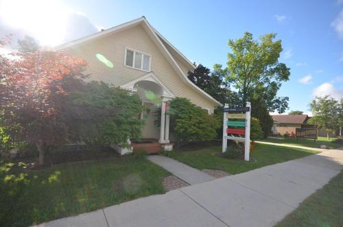 a house with a sign in front of it at Front Cottage "Green Shutter" in Suttons Bay