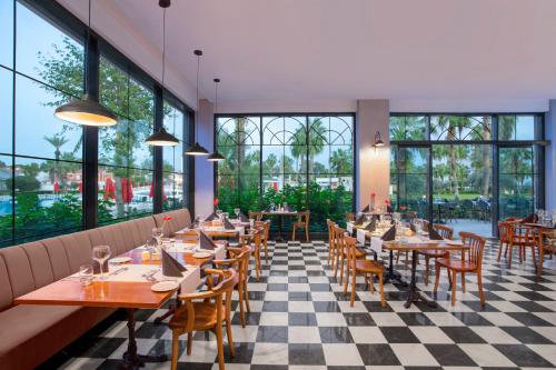 a restaurant with tables and chairs and large windows at IC Hotels Santai Family Resort - Kids Concept in Belek