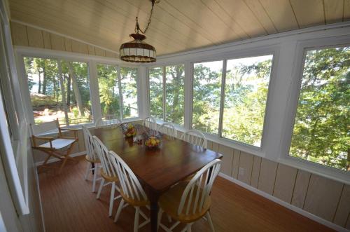 a dining room with a table and chairs and windows at Bella Soleil in Traverse City
