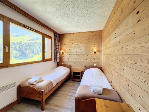 deux lits dans une chambre avec une fenêtre dans l'établissement Résidence Plein Soleil - Lumineux, ski-in, ski-out, location ideal MAE-3731, à Les Allues