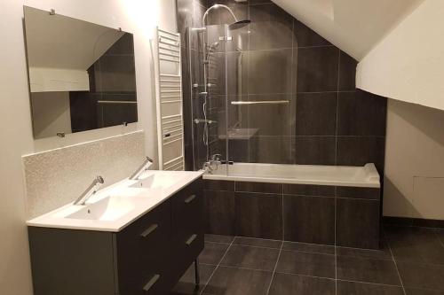 a bathroom with two sinks and a shower and a tub at Loft LINAS in Linas