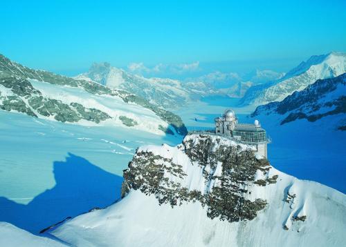 a castle on top of a mountain in the snow at Altogold Swiss Holidays At Manor Farm 5* in Interlaken