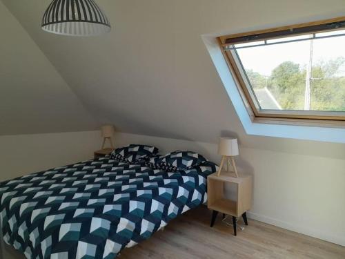 a bedroom with a bed and a window at Grande villa, Entre Audierne et Pointe du Raz in Primelin