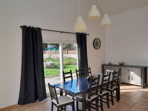 une salle à manger avec une table et des chaises et une fenêtre dans l'établissement Grande villa, Entre Audierne et Pointe du Raz, à Primelin