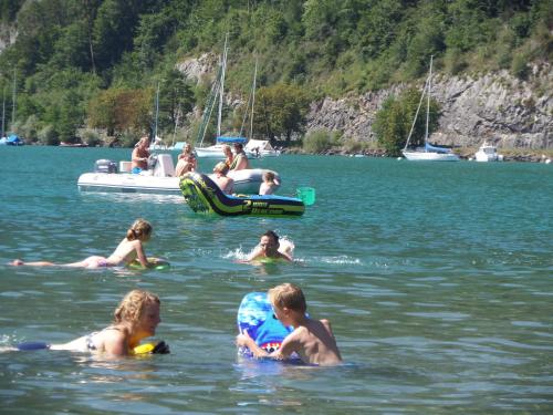 a group of people in the water with a boat at Altogold Swiss Holidays At Manor Farm 5* in Interlaken