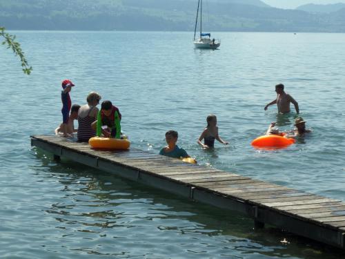 a group of people sitting on a dock in the water at Altogold Swiss Holidays At Manor Farm 5* in Interlaken
