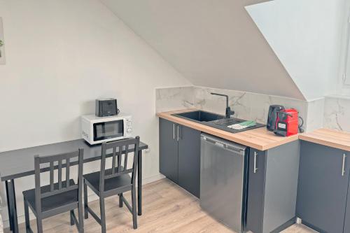 a small kitchen with a sink and a microwave at Cozy Paris Gateway Studio with free parking in Vitry-sur-Seine