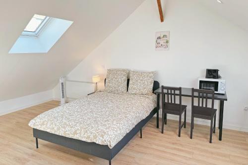 a bedroom with a bed and a table with a microwave at Cozy Paris Gateway Studio with free parking in Vitry-sur-Seine