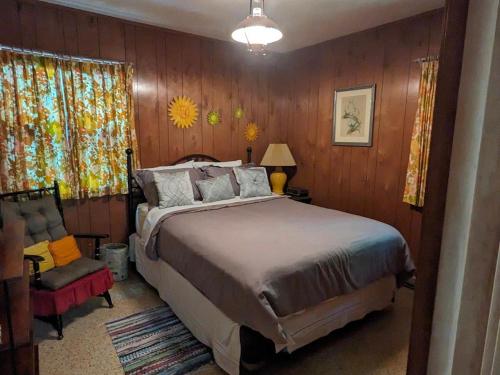 a bedroom with a large bed and a chair at Orchard Oaks Cottage in Glen Arbor