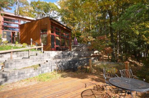 a house with a table and chairs on a deck at Northern Comfort 2--Long Lake-Traverse City in Traverse City