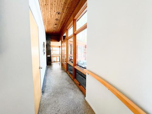 a hallway with a stairway leading to a room with windows at Northern Comfort 2--Long Lake-Traverse City in Traverse City