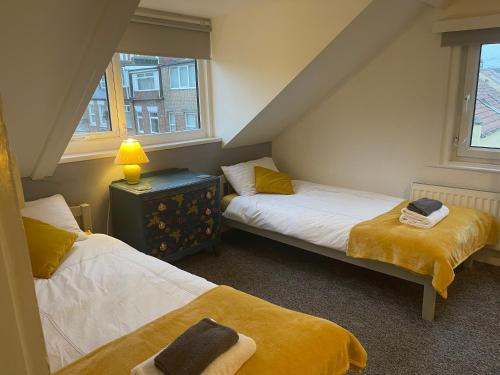 2 Betten in einem kleinen Zimmer mit 2 Fenstern in der Unterkunft Hope Corner in Filey