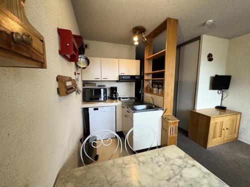 une petite cuisine avec une cuisinière et un micro-ondes dans l'établissement Résidence Serre D'aigle - Studio avec coin montagne · Au pied des pistes · Casier à skis privé MAE-0594, à Champcella