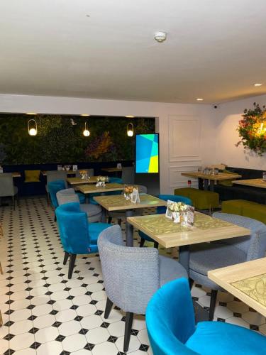 a restaurant with tables and chairs and a tv at Lala's Boutique Hotel in Lagos