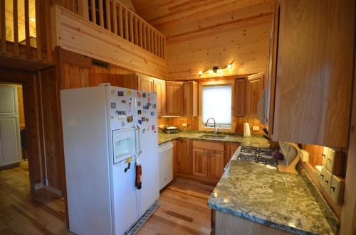 a kitchen with a white refrigerator and wooden cabinets at Marcia Lee Lake House in Suttons Bay