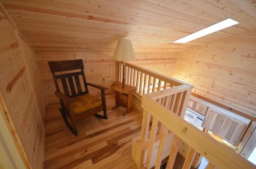 a wooden room with a rocking chair and a lamp at Marcia Lee Lake House in Suttons Bay