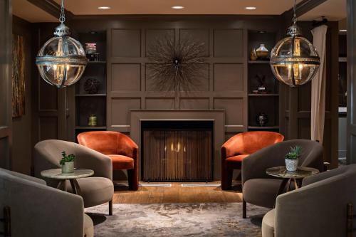 a living room with chairs and a fireplace at Ambassador Hotel Oklahoma City, Autograph Collection in Oklahoma City