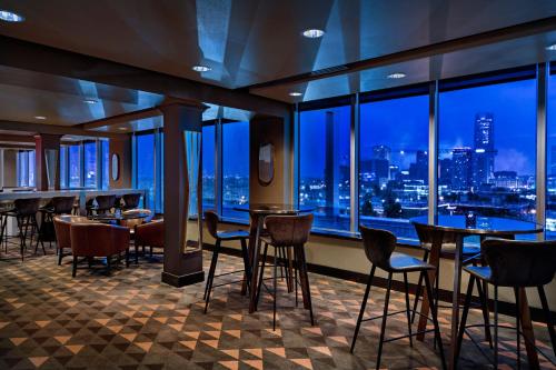 a restaurant with tables and chairs and a view of the city at Ambassador Hotel Oklahoma City, Autograph Collection in Oklahoma City
