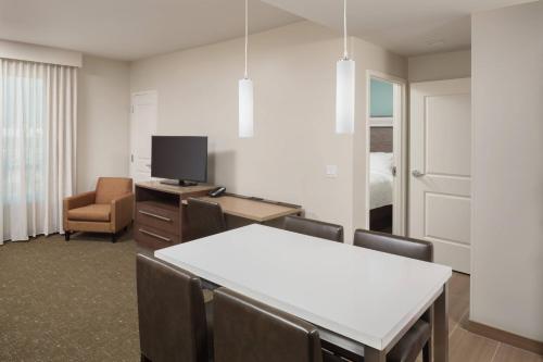 a room with a table and chairs and a television at Residence Inn by Marriott Ontario Rancho Cucamonga in Rancho Cucamonga