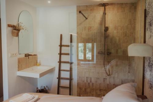 a bathroom with a shower and a bed and a sink at Le verger de Paulin in Yvoir