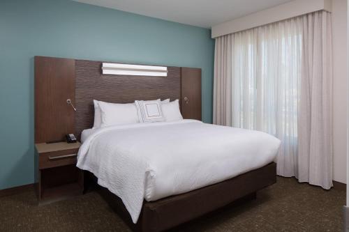 a bedroom with a large white bed and a window at Residence Inn by Marriott Ontario Rancho Cucamonga in Rancho Cucamonga