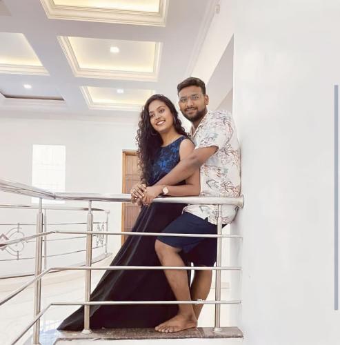 a man and a woman sitting on a railing at La Bay Luxury Beach Bungalow in Puducherry