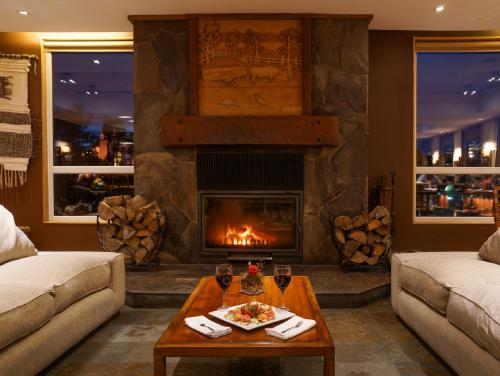 a living room with a fireplace and a table at Solace Hotel Puerto Varas in Puerto Varas