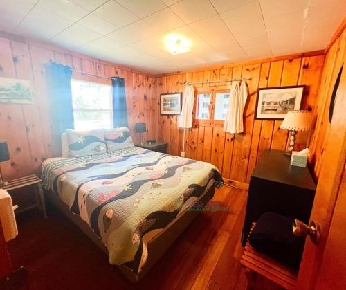 a bedroom with a bed in a wooden room at Shoreline Pines in Suttons Bay
