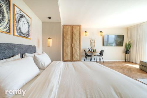 a bedroom with a large bed and a table at Luxury Apartments And Studios At Sea Side By Rently in Eilat