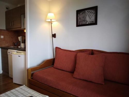 - un salon avec un canapé rouge et une lampe dans l'établissement Résidence Andromede - 2 Pièces pour 5 Personnes 591, à Aime La Plagne