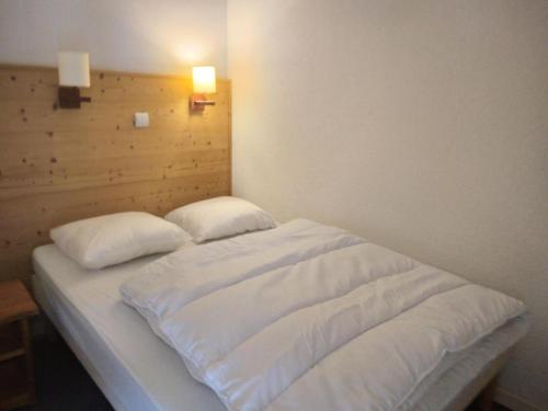 un lit avec des draps blancs et des oreillers dans une chambre dans l'établissement Résidence Andromede - 2 Pièces pour 5 Personnes 591, à Aime La Plagne