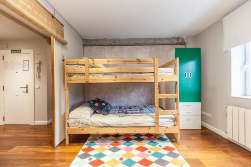 a bedroom with two bunk beds and a rug at Apartamento El Espigón (Cimadevilla) in Gijón