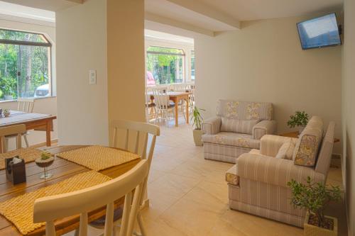 un salon avec un canapé et une table dans l'établissement Pousada Essência do Vale, à Cruzeiro