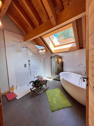 La grande salle de bains est pourvue d'une grande baignoire et d'un lavabo. dans l'établissement Le Chalet du Lys avec jacuzzi, à Les Déserts