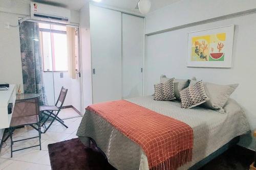 Un dormitorio con una cama con una manta naranja. en Nossa Kitnet no Sudoeste 10 minutos da Esplanada, en Brasilia