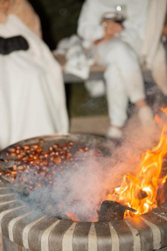 a grill with fire in it with people in the background at Hotel Valbor in Tropojë