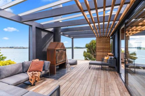 a living room with a couch and a stove on a deck at Black Hut Eco Retreat in Christchurch