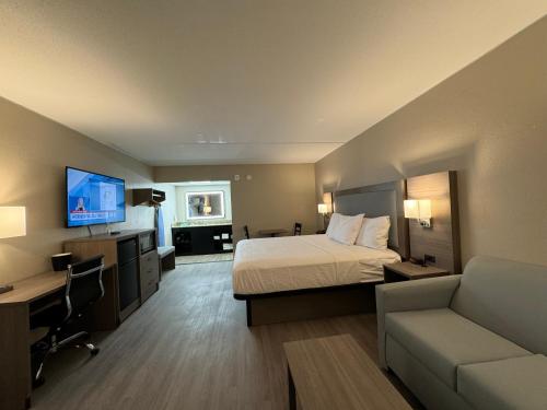 a large hotel room with a bed and a couch at Baymont by Wyndham Corpus Christi Airport in Corpus Christi