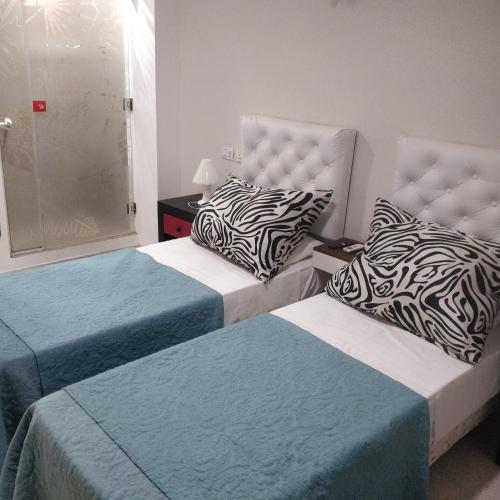 two beds sitting next to each other in a room at Rosa Ramona Rooms in San Salvador de Jujuy