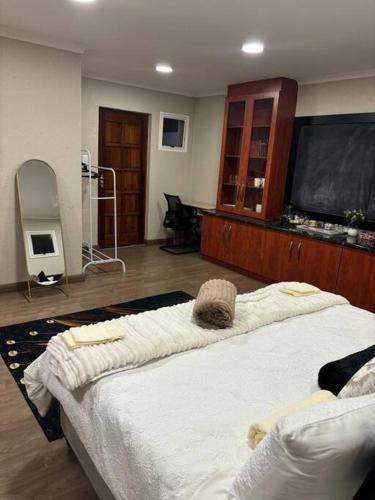 a room with a large bed and a flat screen tv at Joy's Place - Fourways BnB in Sandton