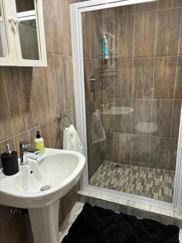 a bathroom with a shower and a sink at Joy's Place - Fourways BnB in Sandton