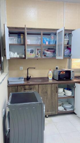 a kitchen with a counter with cabinets and a refrigerator at شقق دار الزيني - Dar Alzainy Apartments in Baghdad