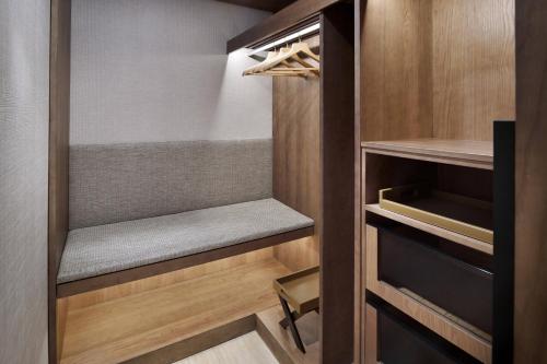 a walk in closet with wooden cabinets and a chair at Sankara Nairobi, Autograph Collection in Nairobi